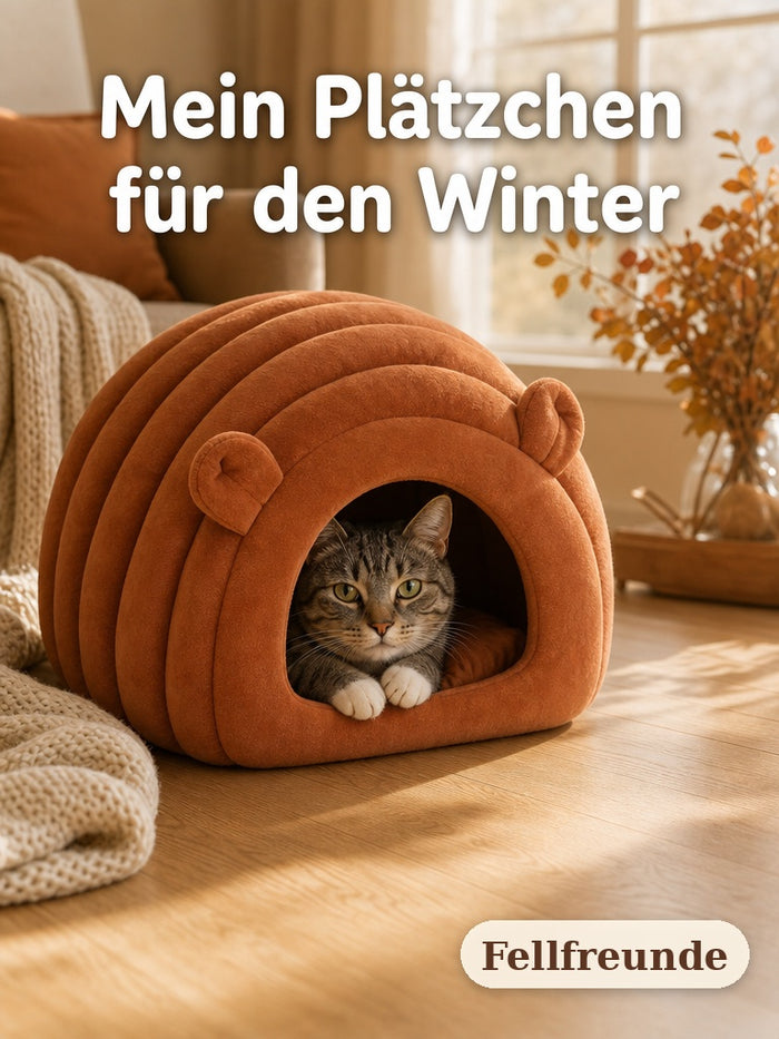 Graugetigerte Katze liegt in der rotbraunen Kuschelhöhle